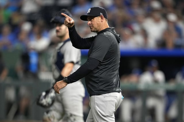 New York Yankees manager Aaron Boone signals for a pitching change in the eighth inning during a baseball game against the Kansas City Royals, Wednesday, June 11, 2025, in Kansas City, Mo. (AP Photo/Ed Zurga)
