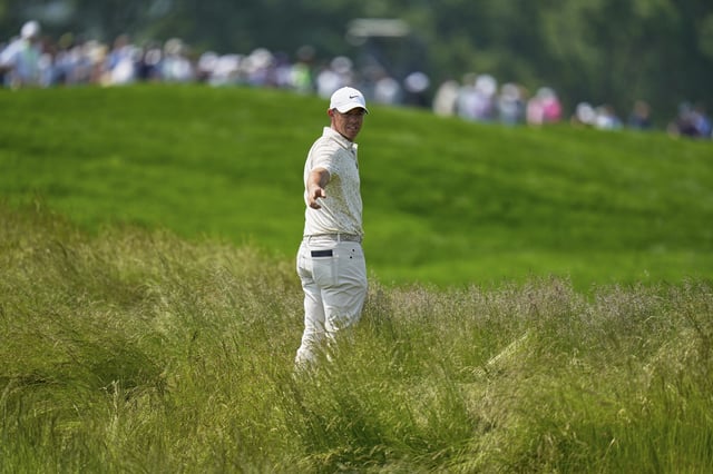 Rory McIlroy eyes up his options before playing out of the tall grass on the fourth hole at Oakmont.