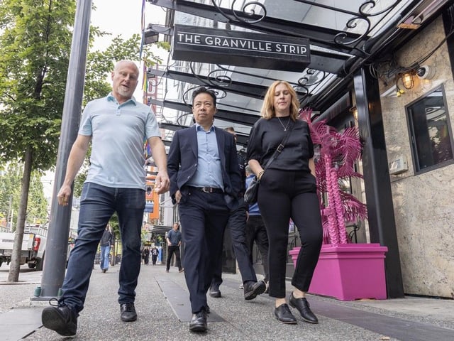  Business owner Allan Goodall, from left, with Vancouver Mayor Ken Sim and Councillor Sarah Kirby-Yung on Granville street June 12, 2025.