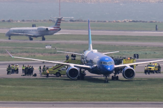 Emergency responders surround a JetBlue plane which rolled off a runway onto a grass area while landing at Logan Airport, Thursday, June 12, 2025, in Boston. (AP Photo/Charles Krupa, Pool)