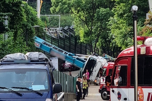 This photo, provided by a reader, shows a ladder truck that has fallen onto its side with the ladder extending over the power supply system of the Gyeongui-Jungang Line in western Seoul on June 13, 2025. (PHOTO NOT FOR SALE) (Yonhap)