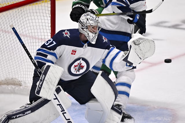 May 17, 2025; Dallas, Texas, USA; Winnipeg Jets goaltender Connor Hellebuyck (37) makes a glove save on a Dallas Stars shot during the third period in game six of the second round of the 2025 Stanley Cup Playoffs at American Airlines Center. Mandatory Credit: Jerome Miron-Imagn Images/File Photo