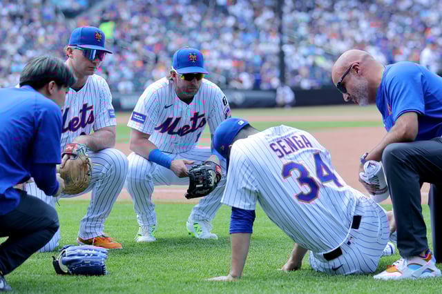 Jun 12, 2025; New York City, New York, USA; New York Mets first baseman Pete Alonso (20) and second baseman Jeff McNeil (1) watch as starting pitcher Kodai Senga (34) is tended to after sustaining an injury during the sixth inning against the Washington Nationals at Citi Field. Mandatory Credit: Brad Penner-Imagn Images