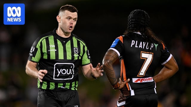 Referee Liam Kennedy speaks with Jarome Luai of the Tigers on the field