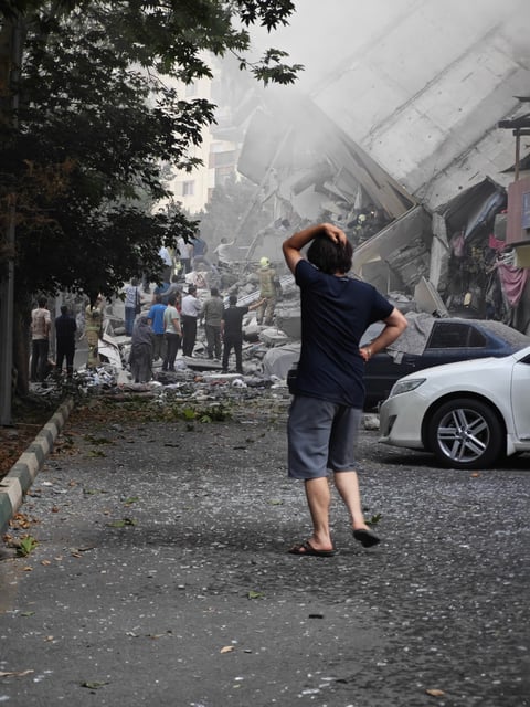 Civilians survey the damage in Tehran on Friday