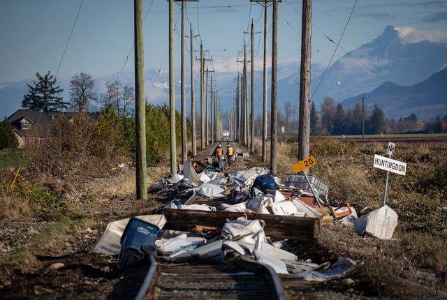 Southern Railway of British Columbia (SRY Rail Link) employees survey a section of rail lines that are washed out in numerous places and covered in flood debris after water receded in Abbotsford, B.C., Friday, Nov. 19, 2021. THE CANADIAN PRESS/Darryl Dyck