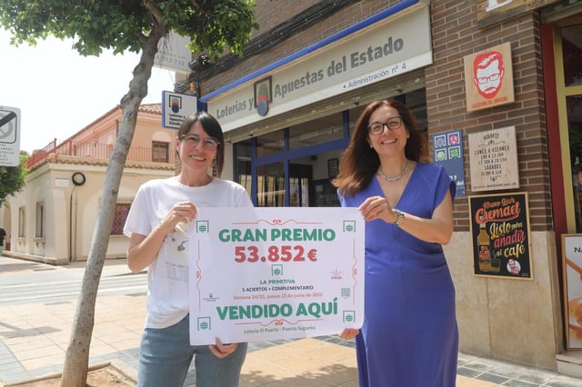 Las responsables de la administración muestran el cartel del premio.