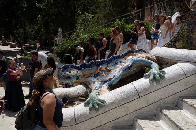 A large group of tourists walk past Gaudi's Dragon fountain at Park Guell while anti-tourism activists across southern Europe team up to pressure authorities to take action against overcrowded cities as they prepare to participate in simultaneous large-scale protests across Spain, Portugal, and Italy on Sunday, in Barcelona, Spain, June 11, 2025. REUTERS/Bruna Casas