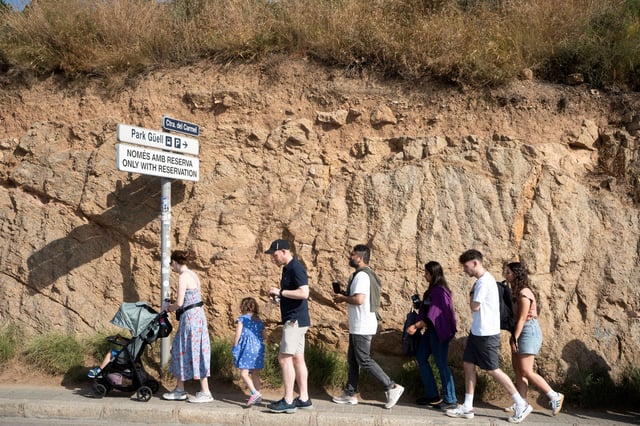 Tourists walk toward one of Park Guell’s entrances after exiting a bus, as tensions grow between neighbours and tourists due to overcrowding on the bus lines serving Park Guell and the nearby neighbourhood of Turo de la Rovira, in Barcelona, Spain, June 12, 2025. REUTERS/Bruna Casa