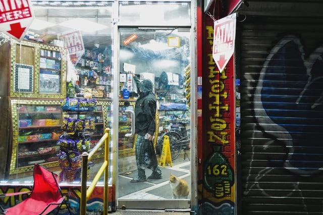 A cat stands at the entrance of a "bodega" in the Washington Heights area of the Manhattan borough of New York City.