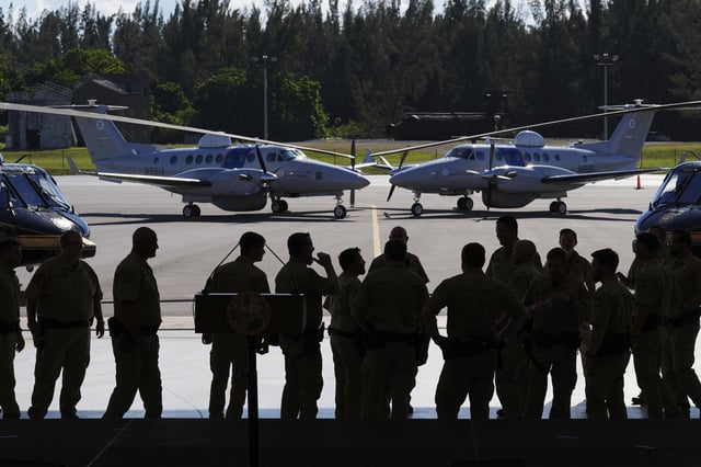 U.S. Customs and Border Protection agents stand in front of CBP planes, ahead of a press conference by Florida Gov. Ron DeSantis at Homestead Air Force Base, Wednesday, Feb. 26, 2025, in Homestead, Fla.
