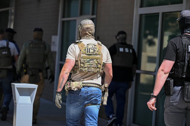 Masked law enforcement officers, including HSI and ICE agents, walk into an immigration court in Phoenix, Arizona, U.S., May 21, 2025.  REUTERS/Caitlin O'Hara/File photo