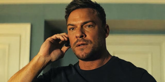 Alan Ritchson's Reacher holding a tiny phone