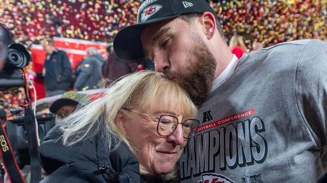 Kansas City Chiefs tight end Travis Kelce (87) kisses his mother, Donna Kelce, on the head after the trophy ceremony following the Chiefs’ 32-29 victory over the Buffalo Bills in the AFC Championship Game on Sunday, Jan. 26, 2025, at GEHA Field at Arrowhead Stadium.
