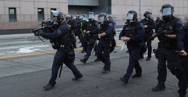 Al Jazeera depiction of militarized LAPD officers moving in to suppress protests against Trump's ICE raids (photo: Jae C Hong/AP)
