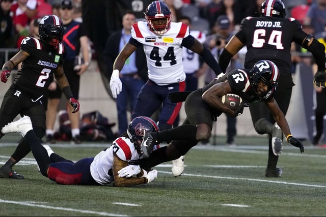 Ottawa Redblacks' Geno Lewis (right) is tackled by Montreal Alouettes' Wesley Sutton (37) during first half CFL football action in Ottawa on Friday.

