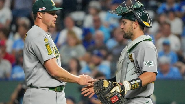 Jun 13, 2025; Kansas City, Missouri, USA; Athletics pitcher Mason Miller (19) celebrates with catcher Austin Wynns (29) after the win over the Kansas City Royals at Kauffman Stadium. Mandatory Credit: Denny Medley-Imagn Images