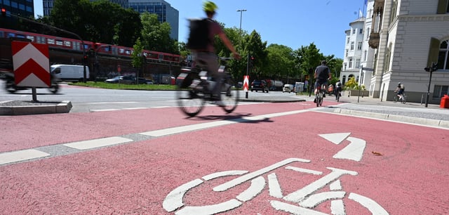 Radfahrer an der Lombardsbrücke in Hamburg auf einem rot markierten Fahrradweg