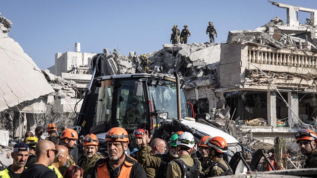Israelische Rettungskräfte sind an einem Ort, an dem eine vom Iran aus abgefeuerte Rakete südlich von Tel Aviv eingeschlagen ist.