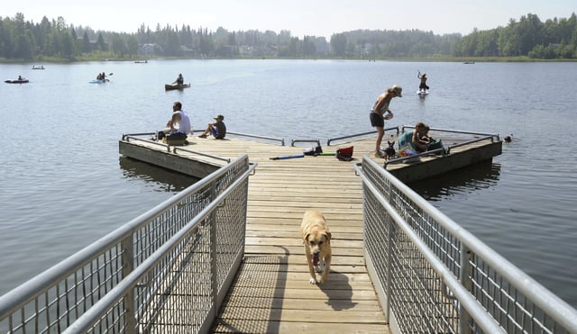 People with their dogs swarm to DeLong Lake hoping to stay cool in the record breaking heat in Anchorage, Alaska, Friday, July 5, 2019.