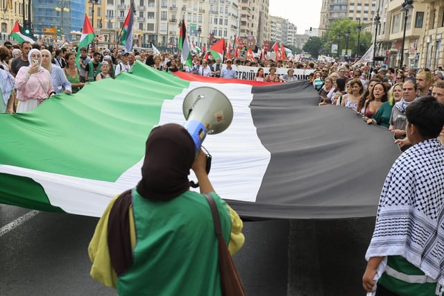Gran bandera palestina desplegada en la manifestación.