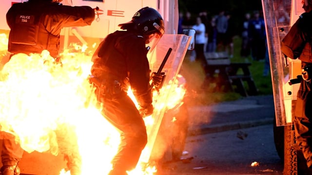 A police officer is engulfed in flames after rioters threw a petrol bomb at officers in Portadown on Sunday