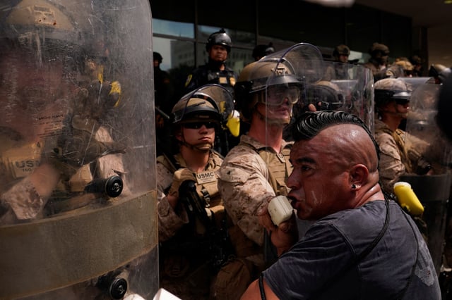 U.S. Marines stand guard as people protest against U.S. President Donald Trump's policies and federal immigration sweeps during a No Kings Day demonstration in Los Angeles, California, U.S., June 14, 2025.  REUTERS/David Ryder