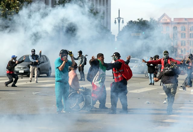 Los Angeles, CA – June 14: People protest through chemical gas on Temple Street after an “unlawful assembly” was declared downtown on Saturday, June 14, 2025 in Los Angeles, CA. (Jason Armond / Los Angeles Times via Getty Images)