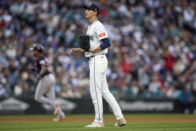 Seattle Mariners starting pitcher George Kirby, foreground, stands on the field as Cleveland Guardians' José Ramírez, back left, rounds the bases on a solo home run during the fifth inning of a baseball game, Saturday, June 14, 2025, in Seattle. (AP Photo/John Froschauer)