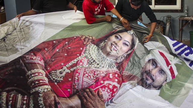 Raja Raghuvanshi's family members, cut out the picture of his wife Sonam Raghuvanshi from a poster of their marriage after she was accused of plotting Raja's murder in Meghalaya, in Indore,