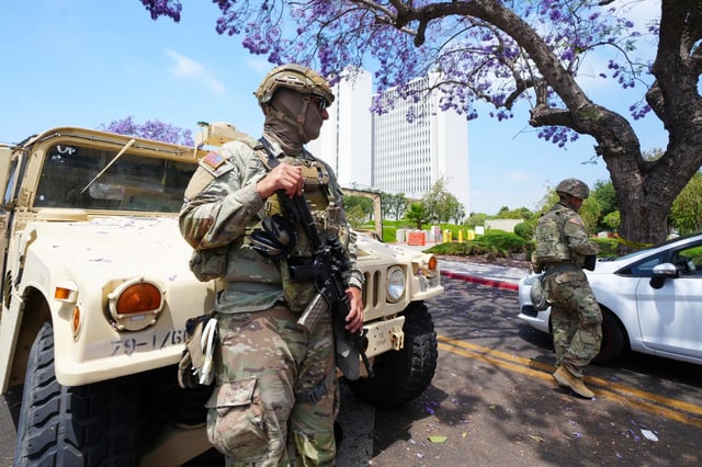 Members of the California National Guard work outside of a federal building Friday, June 13, 2025, in Los Angeles (AP Photo/Damian Dovarganes)