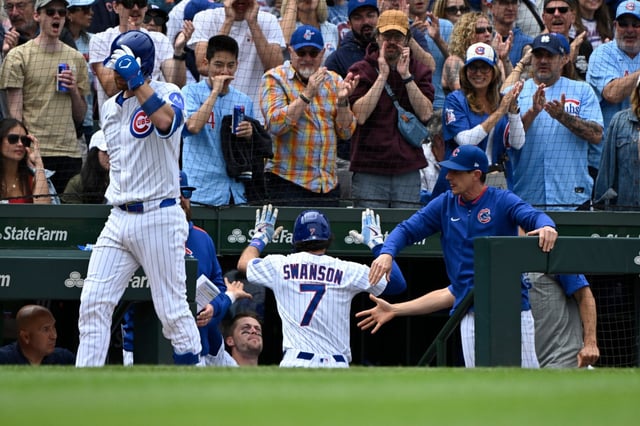 Cubs shortstop Dansby Swanson (7) slaps hands with manager Craig Counsell, right, and others after hitting a solo home run in the sixth inning against the Pirates on Saturday, June 14, 2025, at Wrigley Field. (Matt Marton/AP)