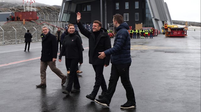 Emmanuel Macron winkt neben Mette Frederiksen (3.v.r.) und Jens-Frederik Nielsen auf dem Flughafen in Nuuk.