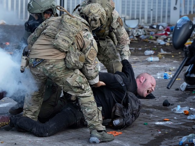 U.S. Customs and Border Protection agents detain a man outside the U.S. Immigration and Customs building during a protest Saturday, June 14, 2025, in Portland, Ore. (AP Photo/Jenny Kane)