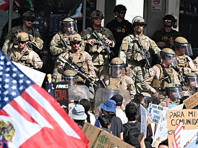US Marines, California National Guard and police stand guard on the steps of the Federal Building on June 14, 2025 in Los Angeles, as protesters participating in the "No Kings" demonstration arrived in the area. Tens of thousands of protesters rallied nationwide Saturday against Donald Trump ahead of a huge military parade on the US president's 79th birthday -- as the killing of a Democratic lawmaker underscored the deep divisions in American politics. "No Kings" demonstrators took to the streets in New York, Los Angeles, Chicago, Philadelphia, Houston, Atlanta and hundreds of other cities across the United States to condemn what they call Trump's dictatorial overreach. (Photo by Robyn Beck / AFP)