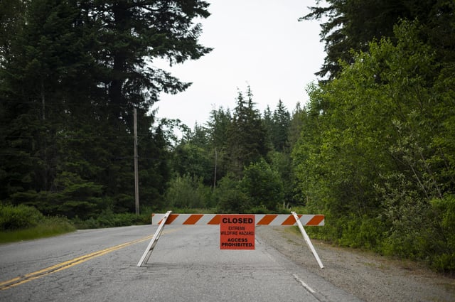 Signage is placed on the road leading to Alice Lake Provincial Park after an evacuation order was issued due to the Dryden Creek wildfire, north of Squamish, B.C., on Wednesday, June 11, 2025. THE CANADIAN PRESS/Tijana Martin