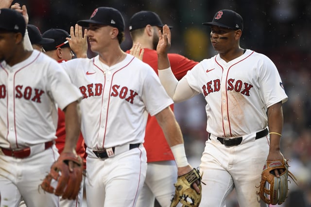 Rafael Devers #11 of the Boston Red Sox high-fives his teammates after their ninth inning win over the San Diego Padres at Fenway Park on June 30, 2024 in Boston, Massachusetts.