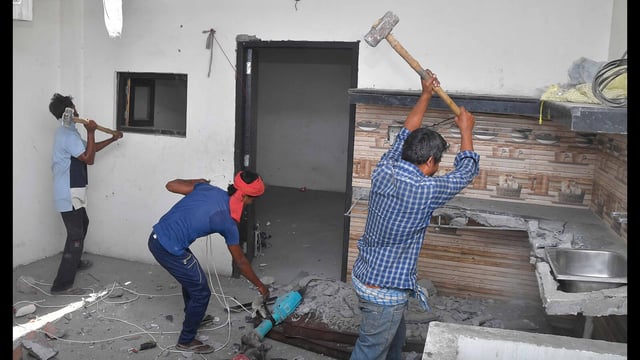 MC workers demolishing the house of a drug peddling accused under heavy police presence in Amarpura Mohalla, Ludhiana, on Sunday. (Manish/HT)