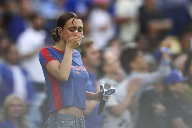 Musical artist Nezza reacts after singing the national anthem in Spanish before the baseball game between the Los Angeles Dodgers and the San Francisco Giants in Los Angeles on Saturday.