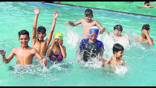 Children splash in a swimming pool on a scorching afternoon in Chandigarh. (Keshav Singh/HT)