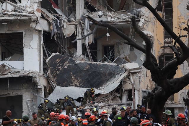 Emergency personnel work at an impact site following a missile attack from Iran on Israel, in Tel Aviv, Israel, June 16, 2025. REUTERS/Ronen Zvulun