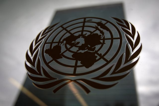 The United Nations headquarters building is pictured though a window with the UN logo in the foreground in the Manhattan borough of New York August 15, 2014. REUTERS/Carlo Allegri/File photo