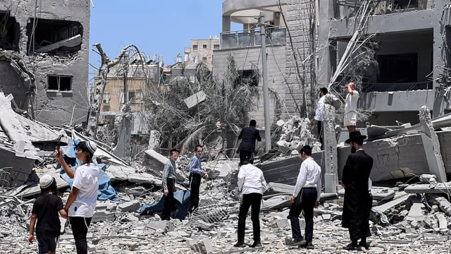 Jews look at an impacted site following missile attack from Iran on Israel, in Bnei Brak, Israel.