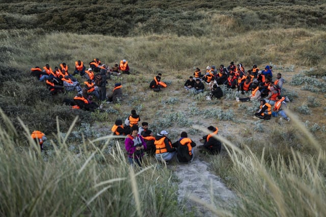 Des migrants, cachés dans les dunes, attendent le bateau d'un passeur et tenter de traverser la Manche au large de la plage de Gravelines, le 16 juin 2025 dans le Nord