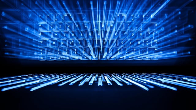 Beleuchtete Tastatur eines Computers vor schwarzem Hintergrund
