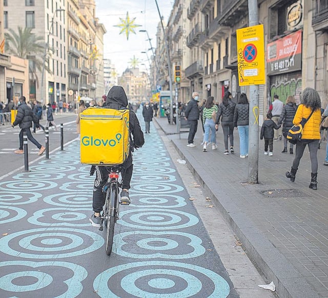 Un repartidor pedalea por el centro de Barcelona