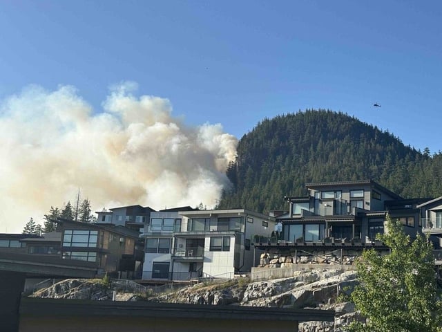  Smoke from an out-of-control wildfire could be seen behind properties in Squamish on June 9, 2025.