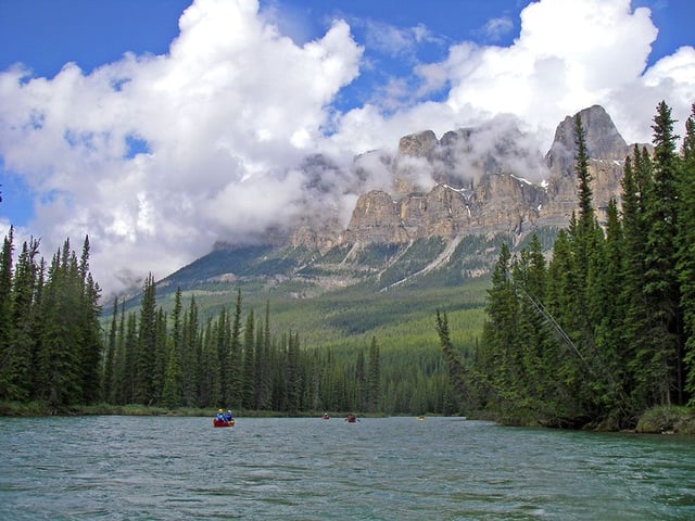 Canoeists enjoy a paddle down the Bow River past Castle Mountain in Banff National Park. 