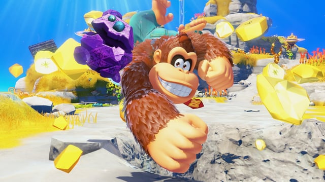 Donkey Kong smashing into the ground next to a purple rock with eyes in Donkey Kong Bananza.