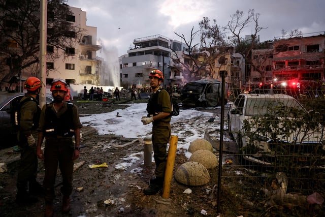 Emergency personnel work at an impact site following a missile attack from Iran on Israel, in Tel Aviv, Israel, June 16, 2025. REUTERS/Ronen Zvulun